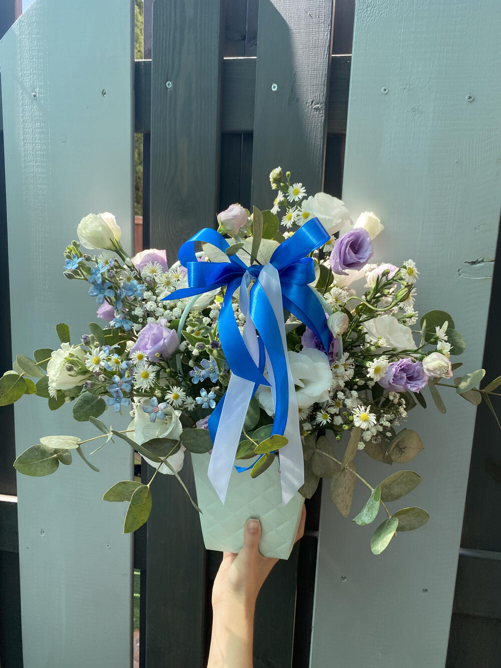 סידור פרחים בסלסלה מליזיאנטוסים סגולים ולבנים,טווידה ואקליפטוסים